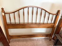 Front view of full-size wooden spindle headboard showing overall design and condition