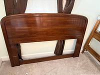 Front view of wooden full-size headboard against wall