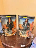 Two sealed Harley-Davidson Barbie dolls in boxes on table
