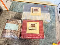 Three packaged bedding items on floor