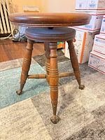 Full view of stool showing round seat, turned legs, cross stretcher