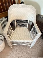 Front view of white wicker armchair showing overall design and condition