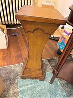 Front view of wood pedestal showing tapered column and base