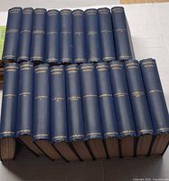 19 blue cloth Thackeray volumes arranged spine-up showing gilt titles