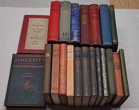 All 20 books grouped, two lying flat and rest standing showing spines