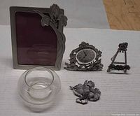 Group shot of Gorham frame, easel frame, pewter clock, birds figurine, clear glass bowl