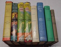 Spine view of all eight books showing titles, publishers and dust jackets