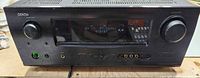 Front view of Denon AVR-2310CI showing display, control knobs, input ports