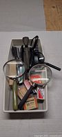 Tray showing magnifying glasses, staplers and staple boxes