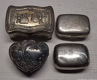 Top view of four metal boxes showing designs and shapes