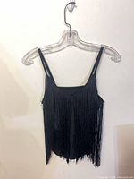 Front view of black fringe cami on hanger