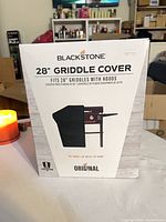 Front of box showing Blackstone 28" griddle cover product image and branding