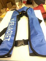 Front view showing LIFEJACKET print, blue nylon panels, front buckle