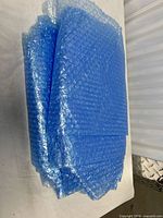 Stack of blue bubble-wrap sheets spread slightly to show individual layers