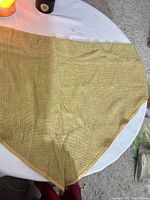 Full view of gold woven table covering spread on table