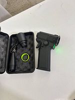 Cordless air duster with LED on, open case showing nozzle, USB cable, gasket ring