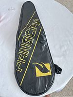 Front view of black FANGCAN racket cover showing full logo and shape