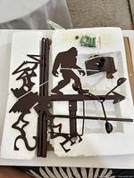 Entire weather vane kit in foam packaging showing Bigfoot silhouette, arrow, anemometer cups, pole sections, mounting bracket and hardware.