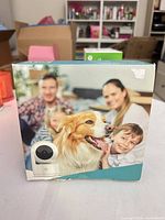 Retail box showing family, dog and small image of white PTZ camera