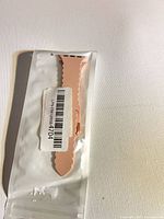 Sealed package showing light pink silicone scalloped watch band
