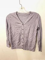 Front view of light purple button-front cardigan on hanger