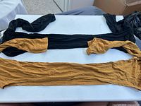 Black and mustard yellow long sleeve tops laid flat