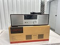 Front view of main unit atop original box, power cord visible