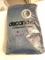 Front of sealed Deconovo curtain package showing navy fabric and grommets