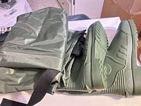 full view of folded olive green chest waders with attached boots