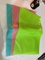 Stack of packaged refrigerator mats showing four colors