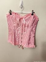 Front view of pink jacquard corset bustier on hanger