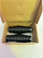 Two black ribbed spring bases in open cardboard box
