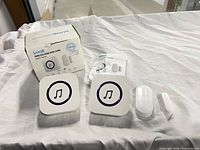 Complete SANJIE MC01 kit showing two receivers, door/window sensor with magnet, box and manual