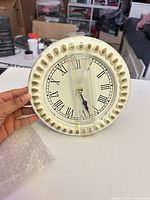 Front view showing cream bead border and Roman numeral face