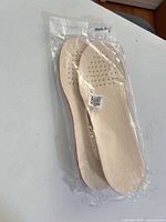 Top view of sealed package showing white perforated insoles
