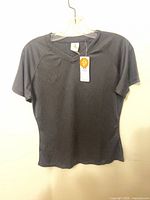 Front view of dark short sleeve V-neck shirt on hanger