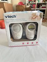 Front of boxed VTech DM1211 baby monitor showing both units through window