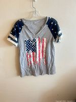 Full front view of T-shirt on hanger showing graphic and sleeve design