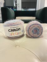 Front view of two Caron Latte Cakes yarn balls with label visible