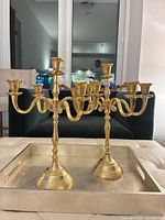 Front view of both brushed gold 5-arm candelabras