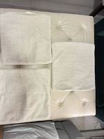 Three cream cushion covers laid flat showing overall appearance and size
