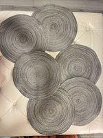 All six grey silver woven round placemats arranged together