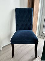 Front view of blue velvet tufted dining chair