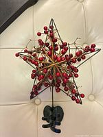 Front view of star topper showing berries and twig details