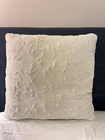 Front view of one white faux-fur pillow