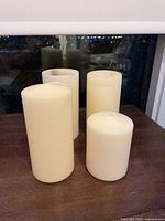 Four ivory pillar candles grouped on tabletop