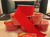 six red felt ribbon rolls stacked with Instant Tac pack
