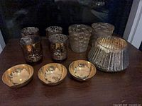 Group shot of all 10 candle holders: 4 bronze glass, 3 distressed silver glass, 3 gold metal bowls
