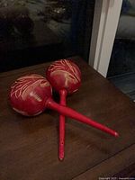 Pair of red wooden maracas on table