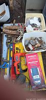 Overview of assorted hand tools on table and totes